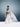 Model wearing a sheer white dress with a blurred background